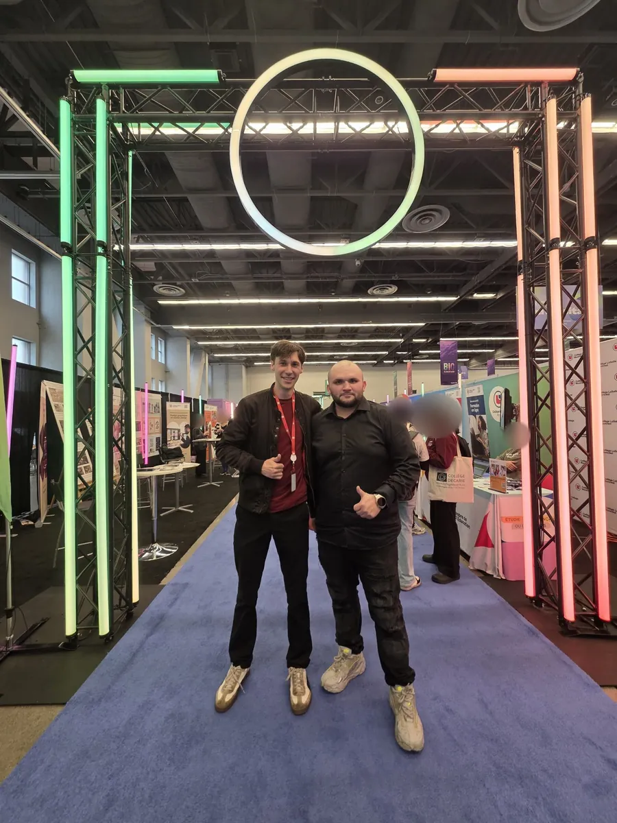 Raphaël et Paul, de l'équipe d'Ékole, sous une arche lumineuse au Salon national de l'éducation.